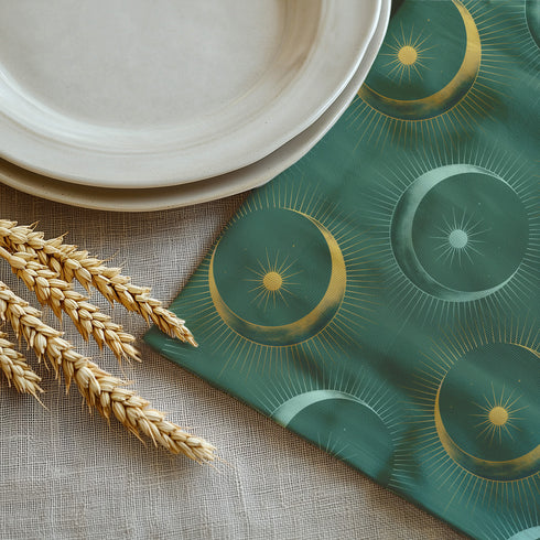 Four-piece cloth napkin set featuring a celestial print of radiant golden crescent moons and pale sunburst orbs against a rich emerald green background. Each napkin displays symmetrical, glowing motifs inspired by lunar phases and cosmic geometry. The fabric is neatly folded to showcase the repeating pattern, with a soft matte finish and fine detailing, perfect for mystical or magical table settings, altar decor, or celestial-inspired dining aesthetics.